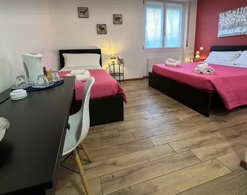 La camera fucsia, con due letti e il parquet